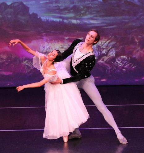 Young ballet student performing with a male guest artist on stage